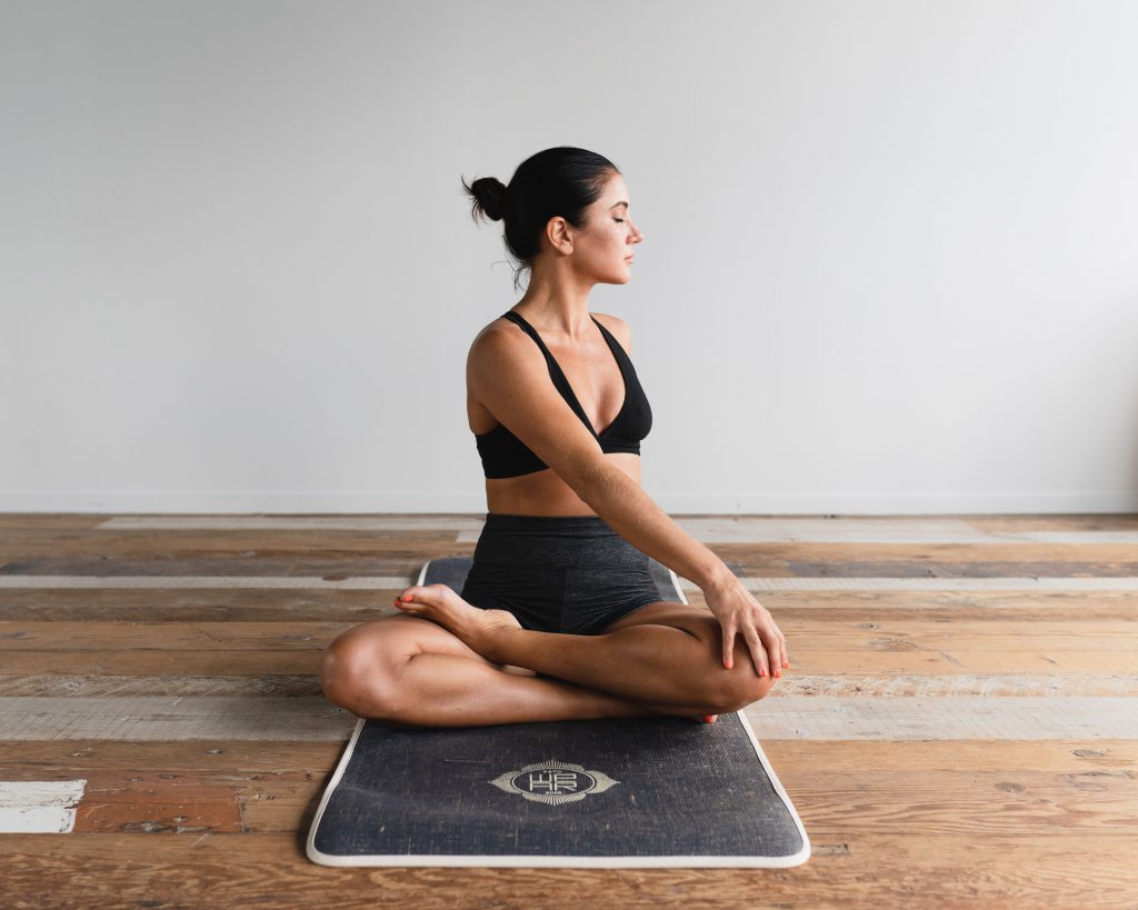 Woman in yoga studio sitting in yoga pose